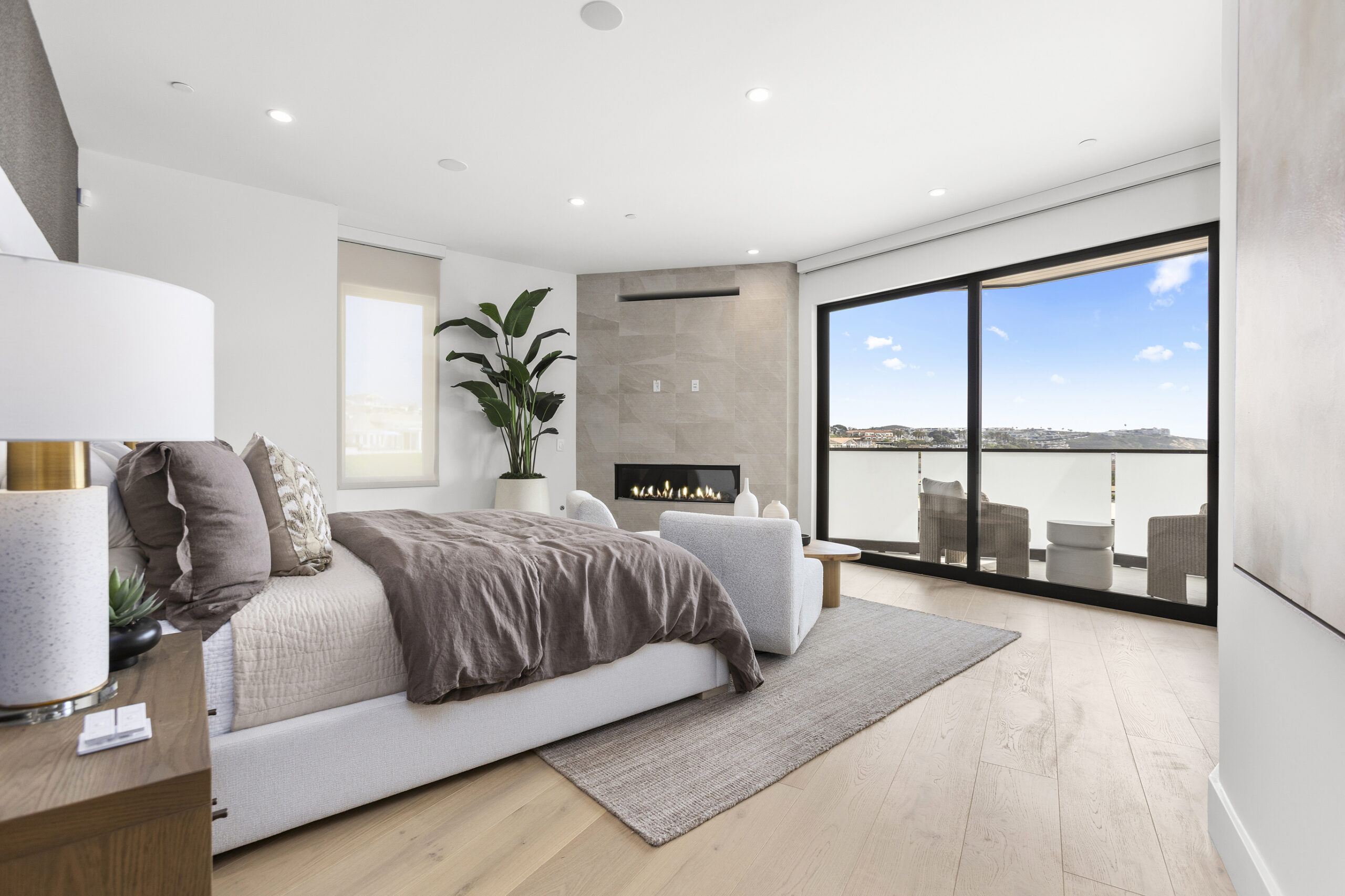 The primary suite is a true retreat, offering serene ocean views and a contemporary linear fireplace.
