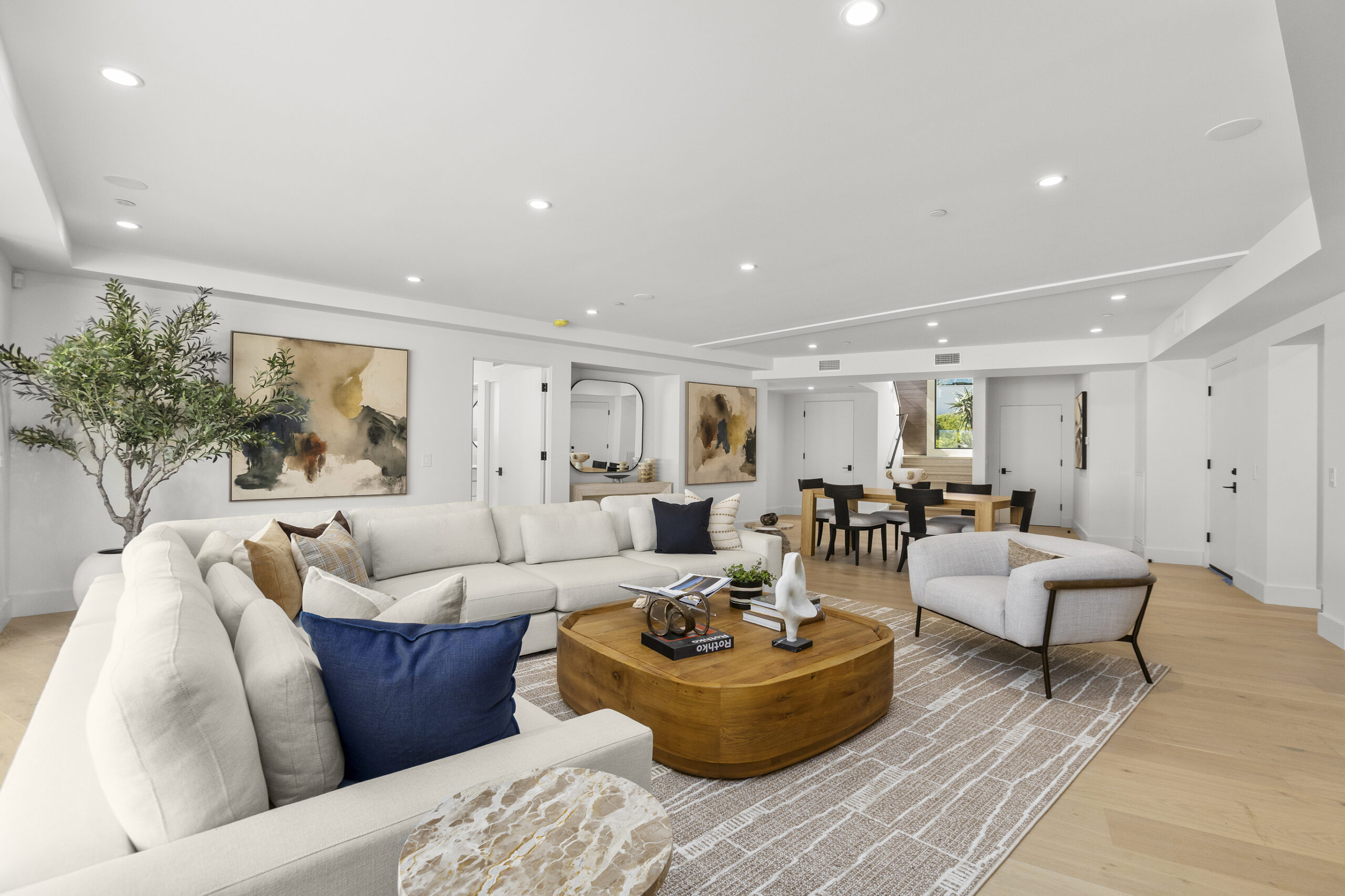 lower level lounge area with large white sectional and wood coffee table