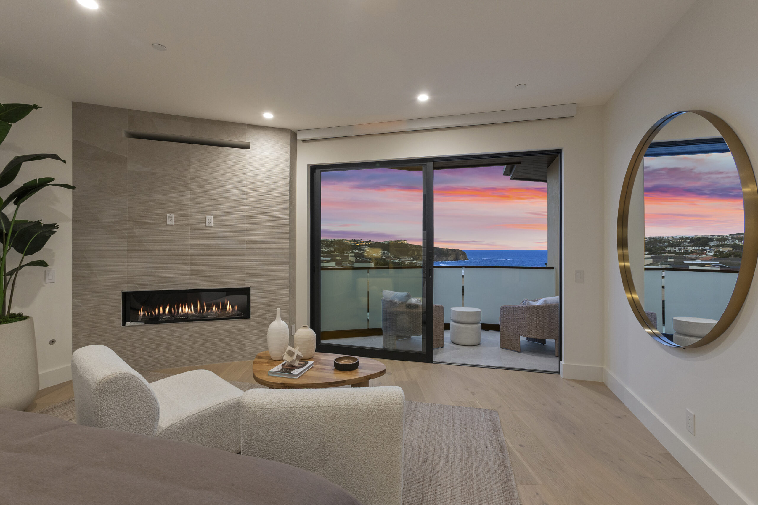 The primary suite is a true retreat, offering serene ocean views and a contemporary linear fireplace.