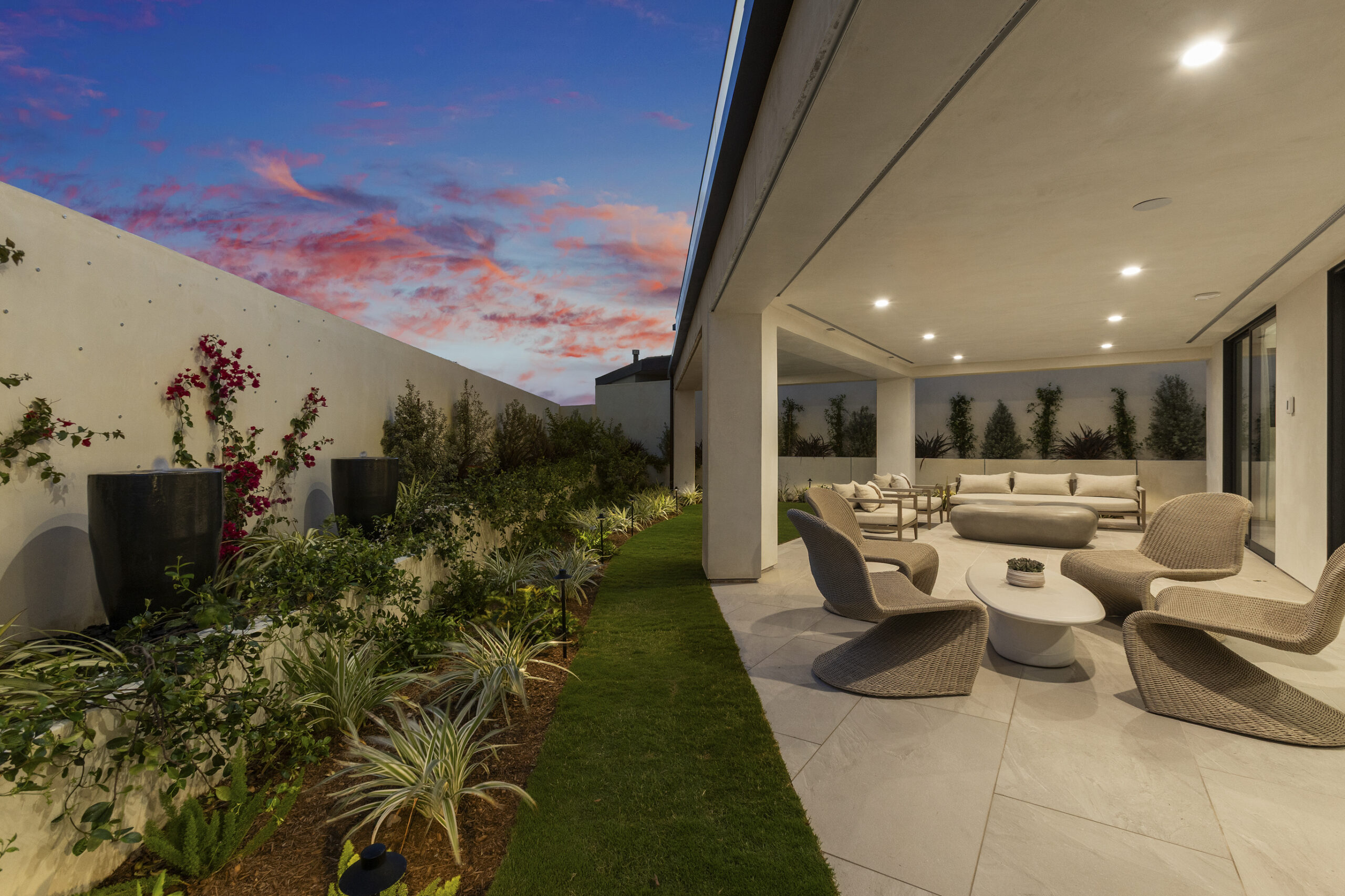 Thoughtfully composed landscaping as viewed from the covered patio with modern lounge furniture.